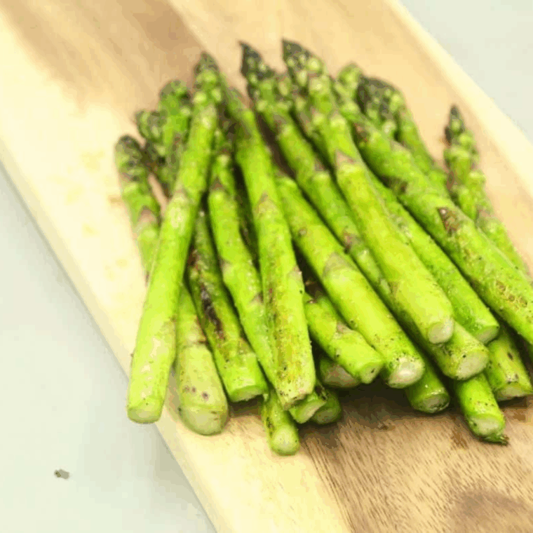 Lemon juice squeezed over charred asparagus fresh off the griddle