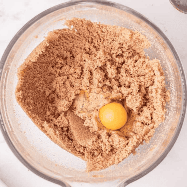 Wet ingredients being mixed and combined with dry ingredients to form cupcake batter.