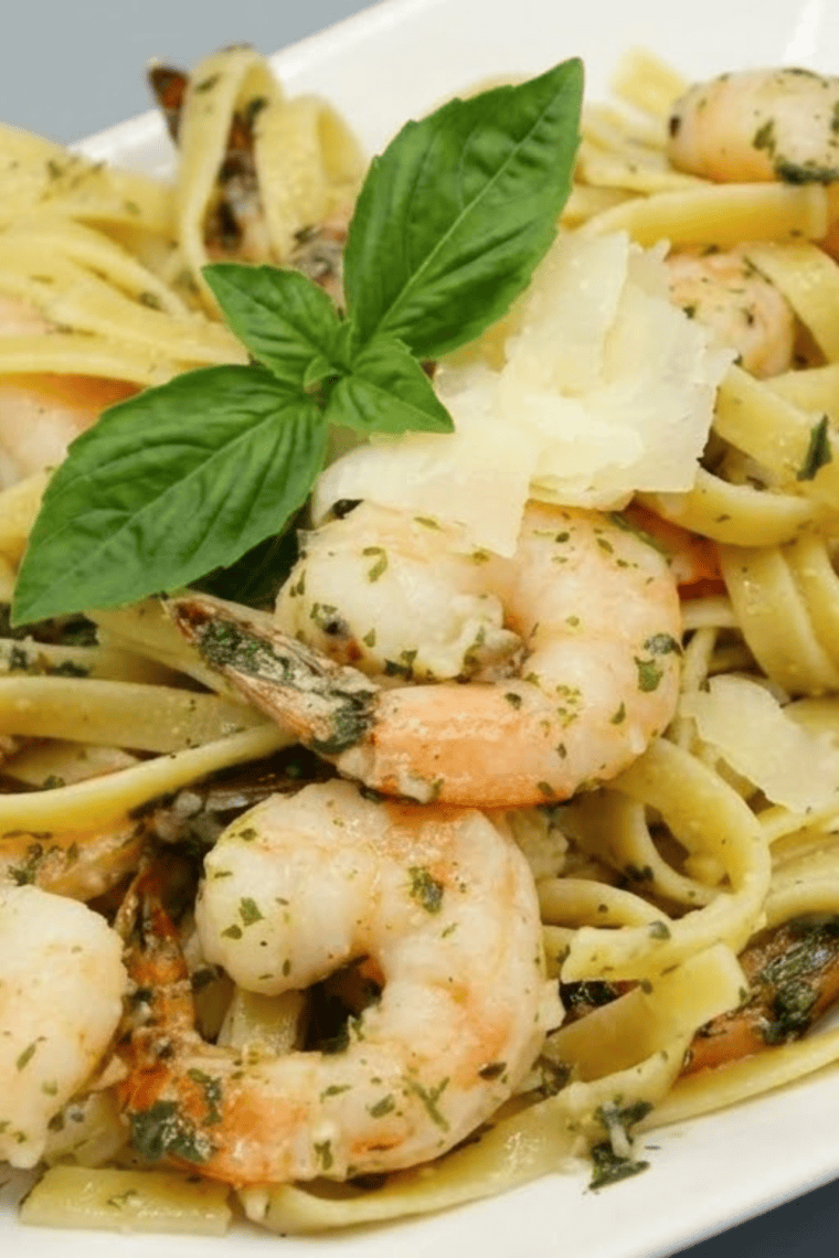 Golden crispy air fryer shrimp coated with garlic, parmesan, and fresh parsley on a plate.