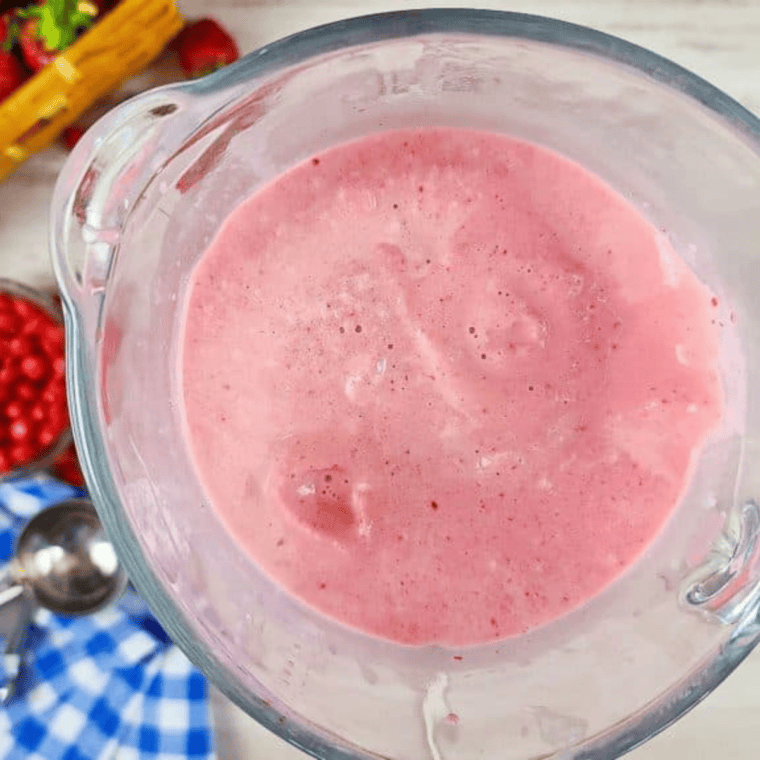 Homemade-style vanilla ice cream in a blender, ready to mix with crushed Skittles freeze pops for a thick milkshake.