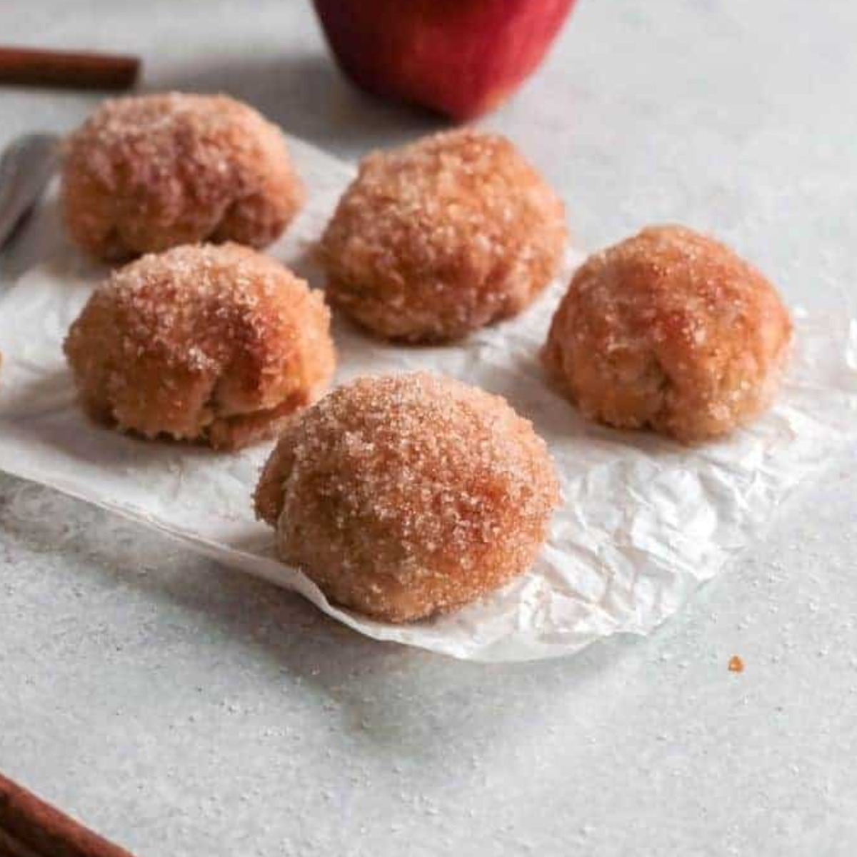 Air fryer apple pie bombs (cinnamon sugar stuffed apple donuts) on a white plate