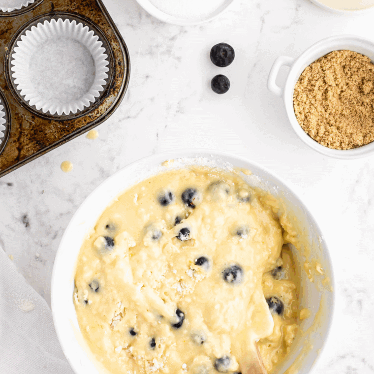 Folding fresh berries gently into muffin batter