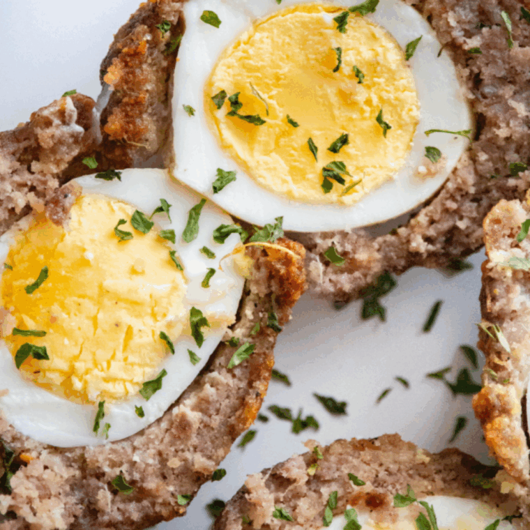 Golden-brown air fryer Scotch eggs sliced open showing cooked sausage and soft egg center
