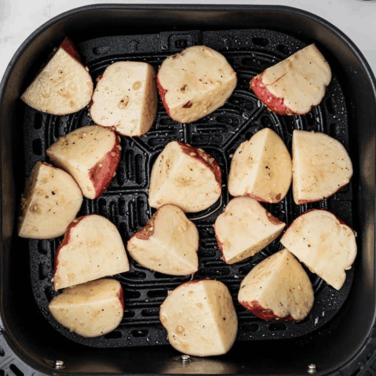 Lightly spray the air fryer basket with oil, cook potatoes for 15–20 minutes, and serve hot.