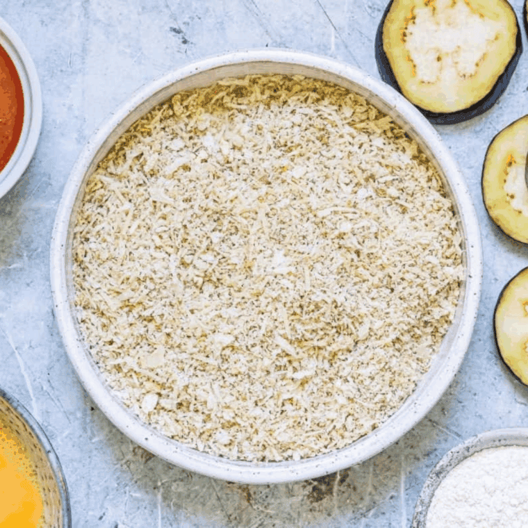 Whisked egg and seasoned breadcrumb mixture prepared in bowls for coating eggplant slices.