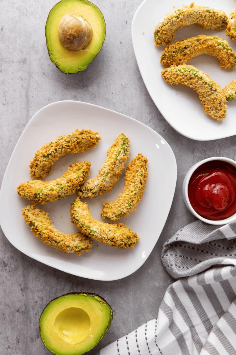 Gluten-free air fryer avocado fries crispy golden and served with dipping sauce.