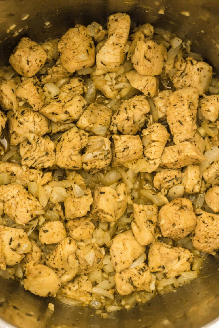 Stirring butter and shredded cheese into cooked chicken and rice
