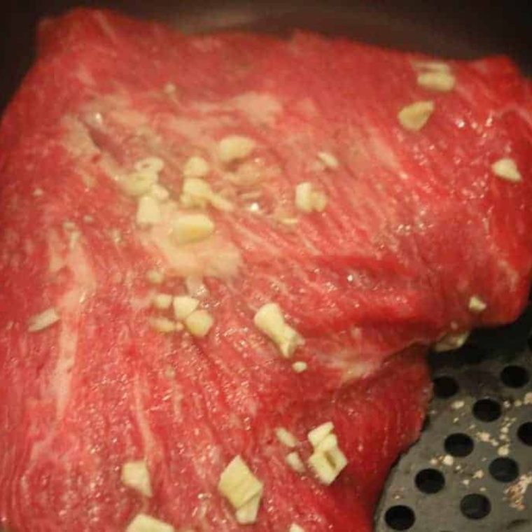 Arrange in a Single Layer: Tri-tip steak slices placed in air fryer basket without overlapping.