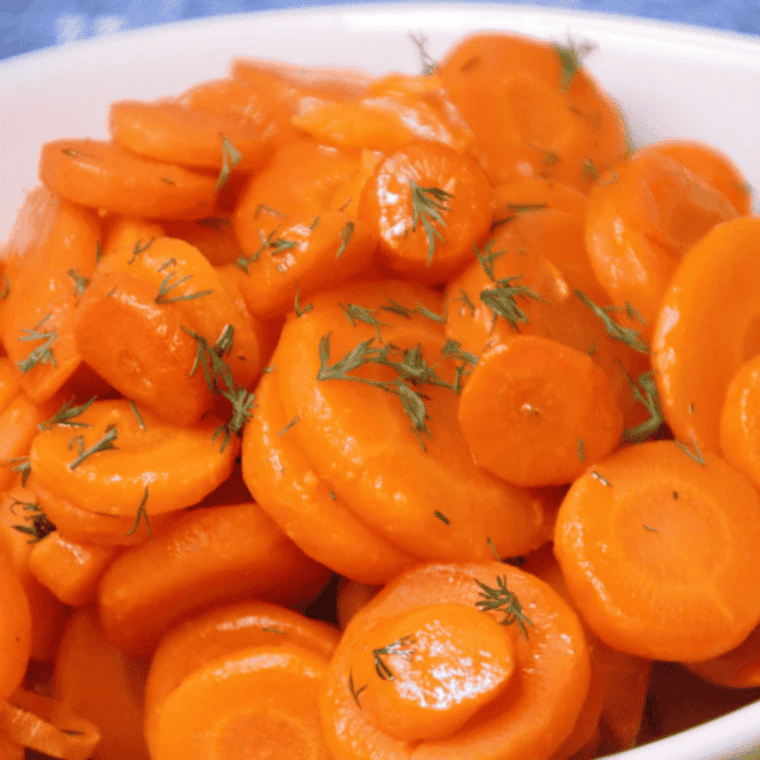 Air fryer cooked canned carrots served in a white bowl, garnished and ready to eat.