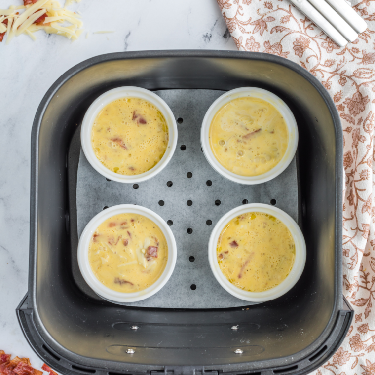 Egg and cheese mixture poured into a greased muffin tin before air frying