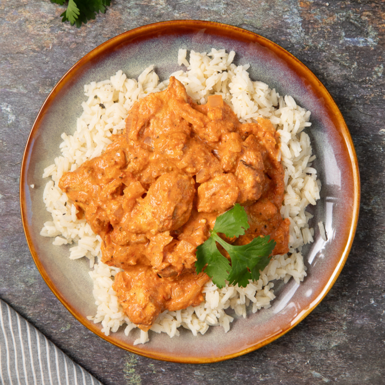 Air Fryer Chicken Tikka Rice Bowl with seasoned chicken, fluffy rice, colorful vegetables, and garnished with fresh herbs