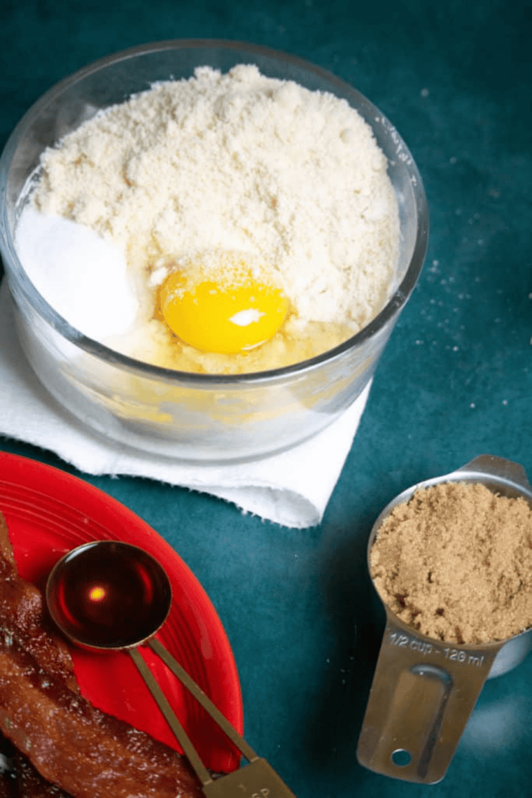 Microwave mozzarella and cream cheese in a bowl until smooth while bacon crisps and air fryer preheats.