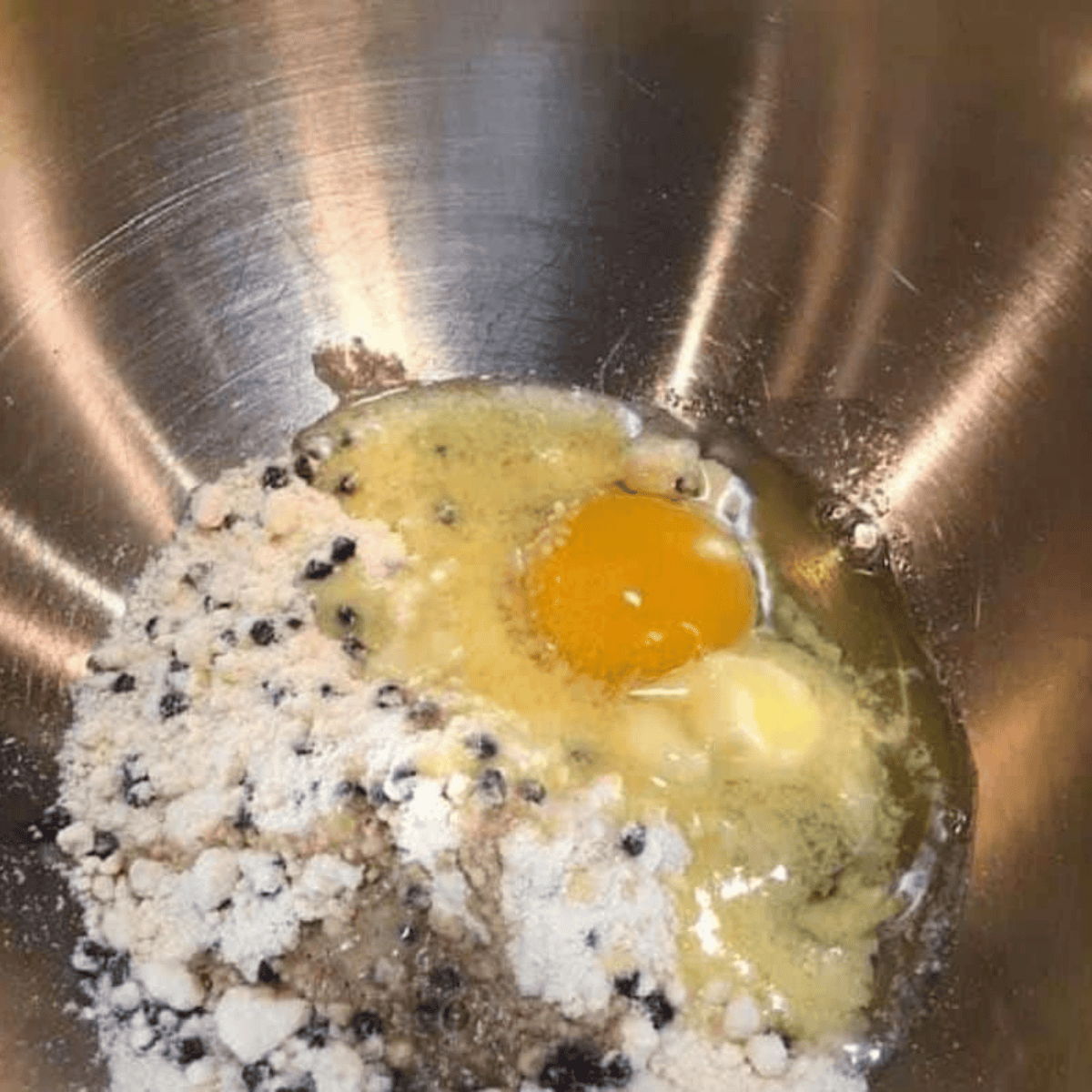 Mixing Jiffy Blueberry Muffin Mix, egg, vanilla, and melted butter in a bowl.