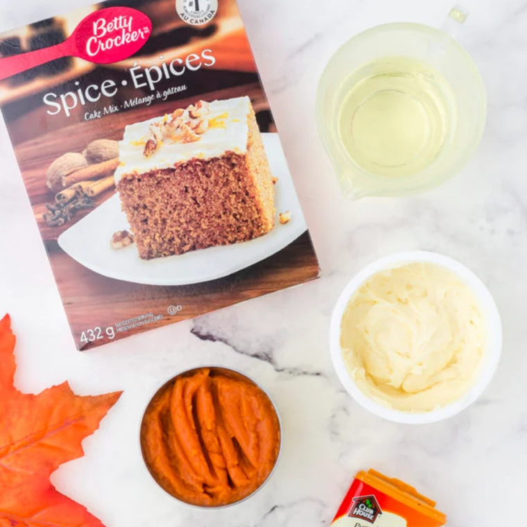 Ingredients for air fryer pumpkin spice cupcakes including spice cake mix, canned pumpkin, eggs, and oil