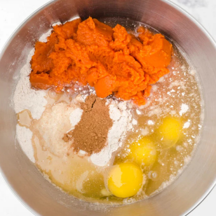 Spice cake mix and pumpkin puree in a stand mixer bowl before mixing