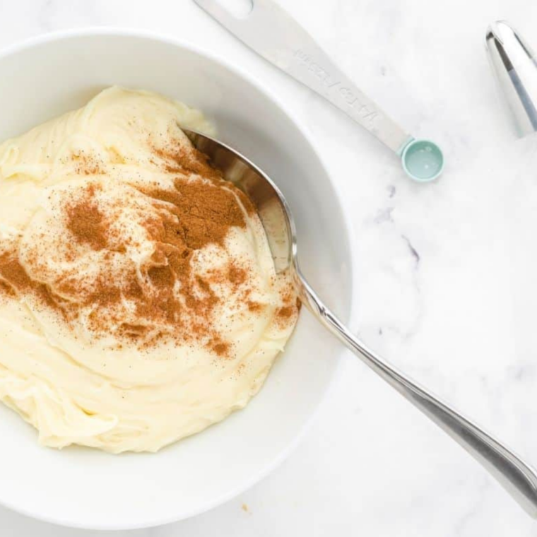 Cream cheese frosting being beaten in a mixing bowl