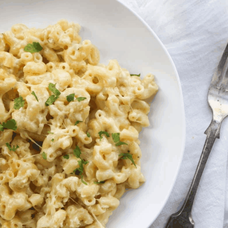Bowl of creamy, rich Chili's White Cheddar Mac and Cheese topped with parsley and tender elbow macaroni.