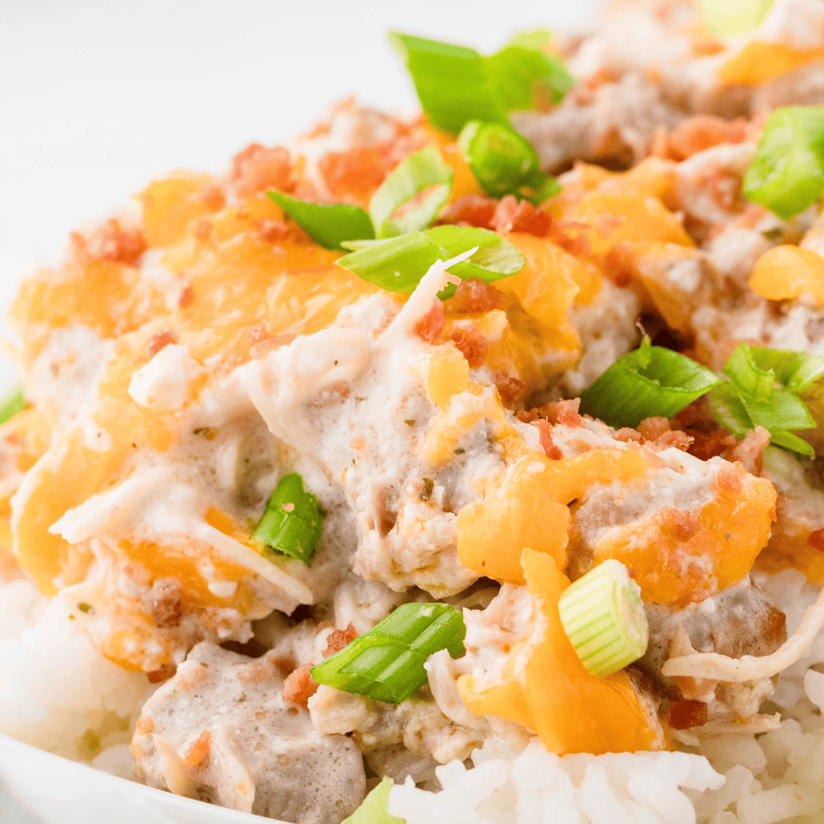 Stirring shredded cheddar into creamy crack chicken in the Instant Pot