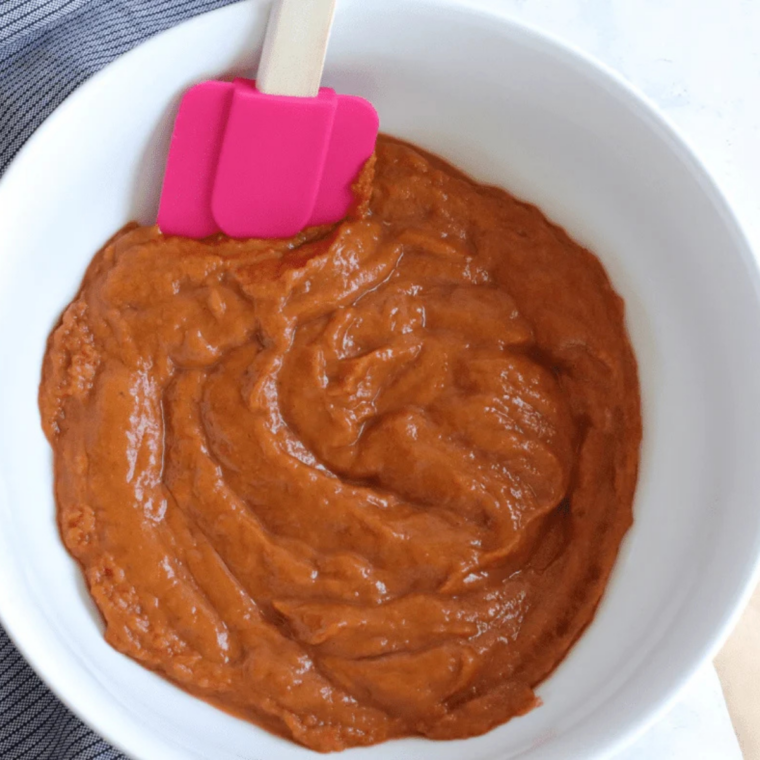 Pumpkin purée, brown sugar, eggs, and pumpkin pie spice whisked smooth in a glass mixing bowl