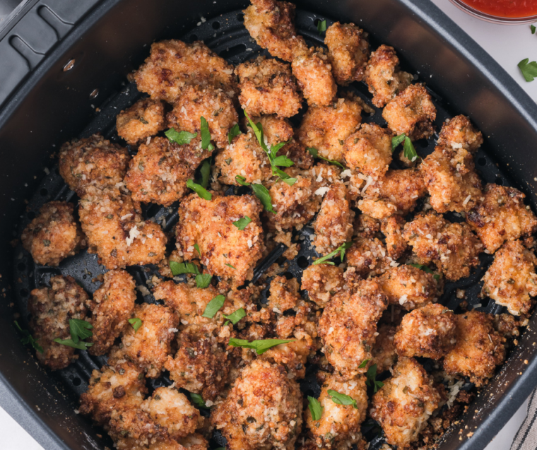 Golden air fryer garlic parmesan chicken bites in an air fryer basket, fresh from cooking