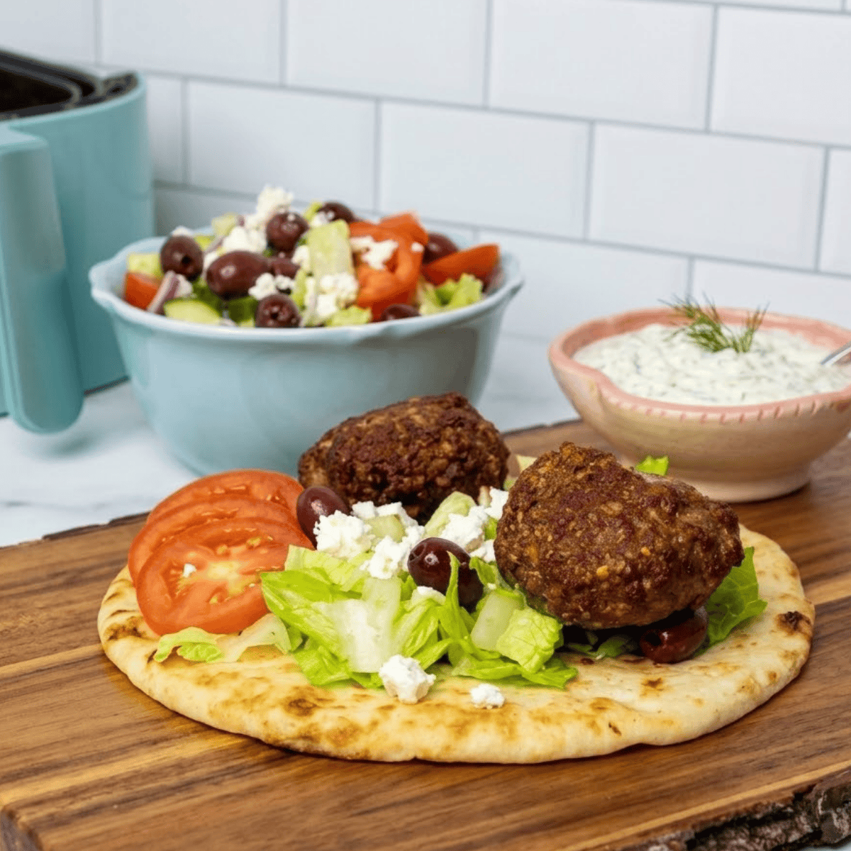 Juicy air fryer lamb gyro patties stacked in a folded pita with fresh toppings