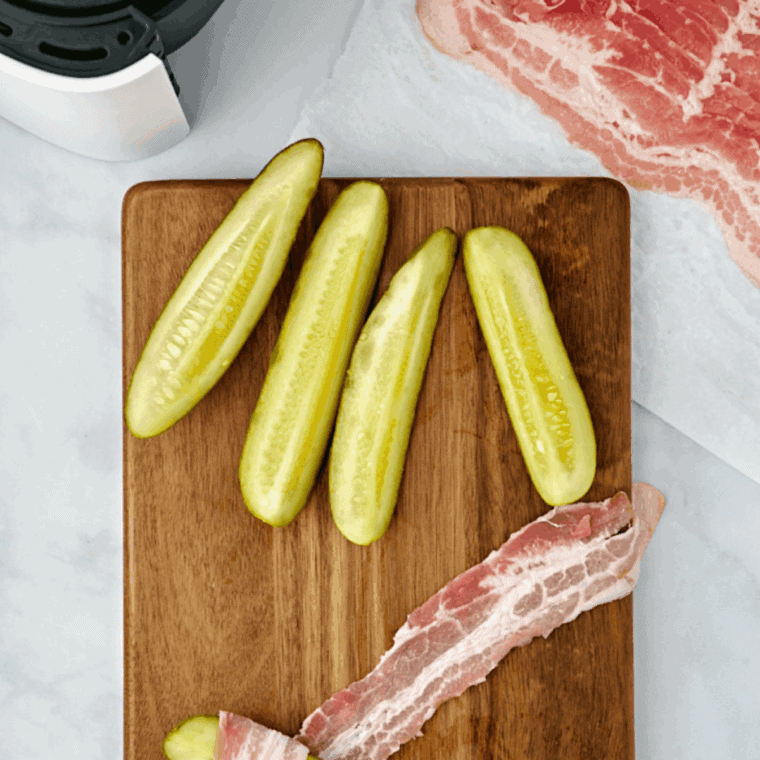 Wrapping a strip of bacon tightly around a dill pickle before air frying