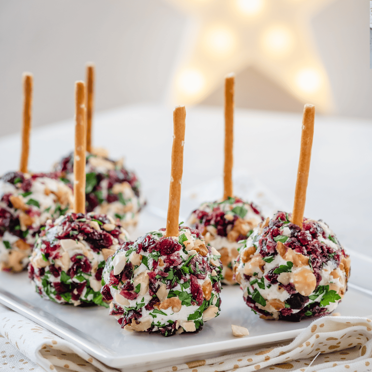 Festive Cranberry Pecan Cheese Ball on a serving plate, creamy center with tangy cranberries and crunchy pecans.