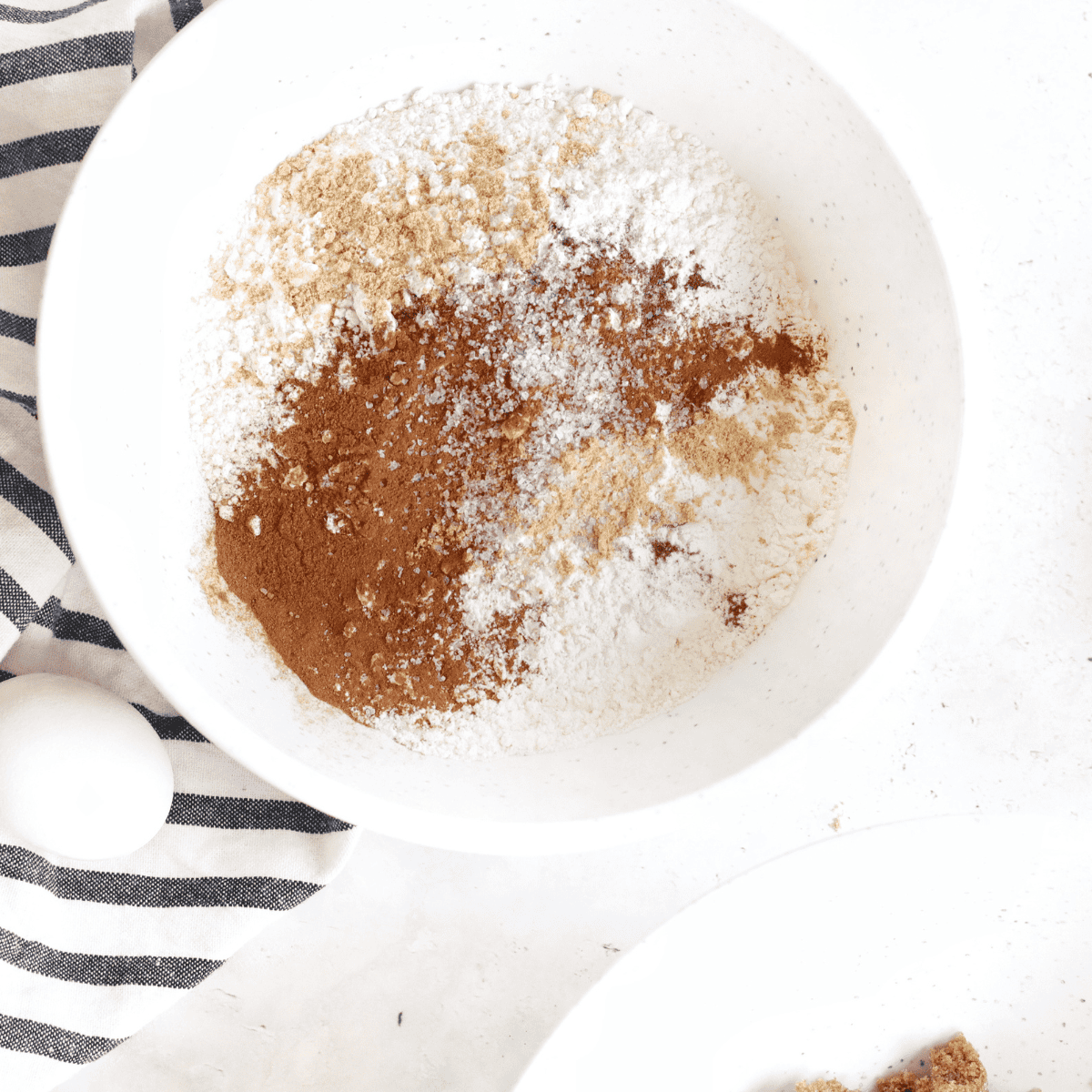 Mixing dry ingredients in one bowl and creaming butter, sugar, and molasses in another before combining for gingersnap cookie dough.