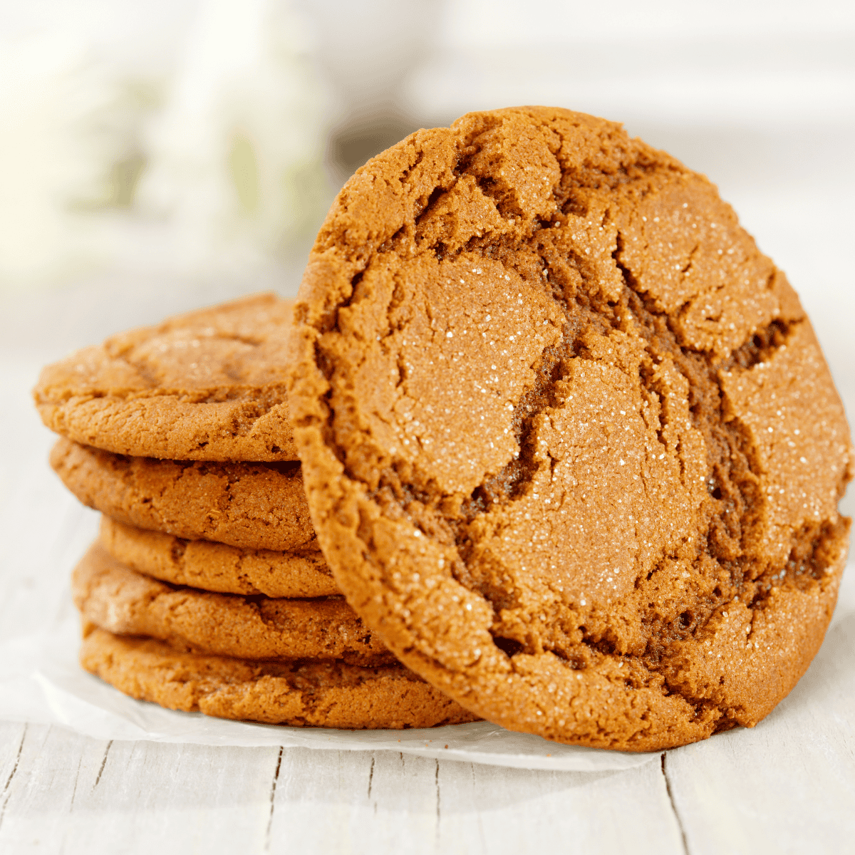 Air fryer gingersnap cookies with cracked tops and a golden brown finish on a cooling rack.