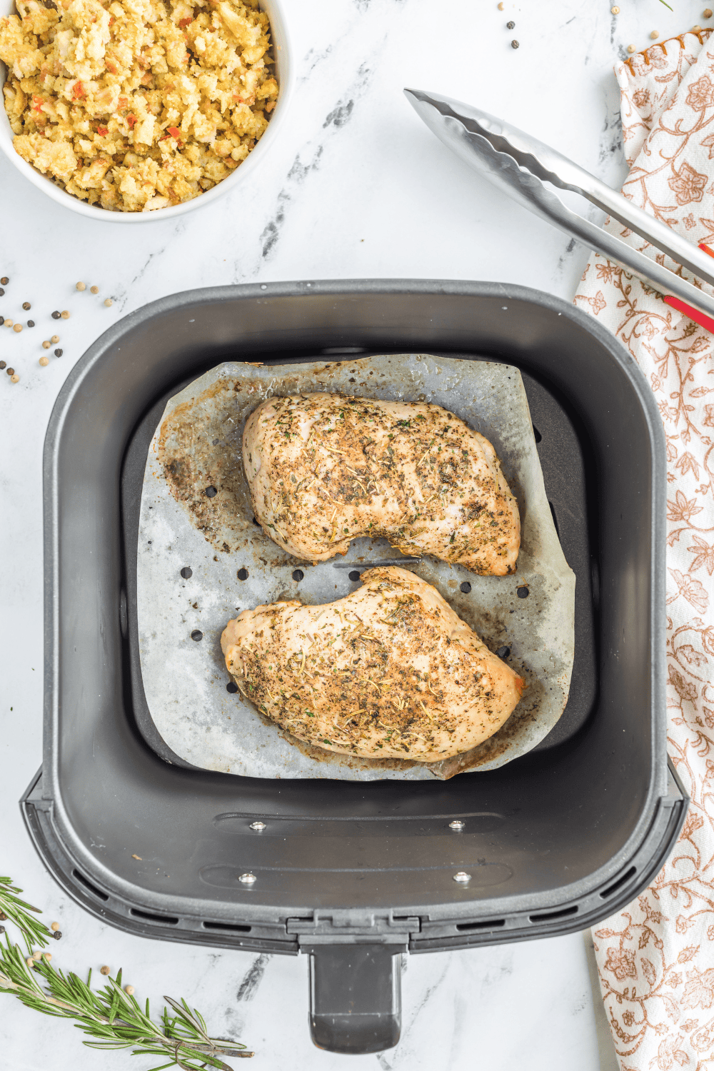 Seasoned turkey tenderloin cooking in an air fryer basket, turning golden brown.