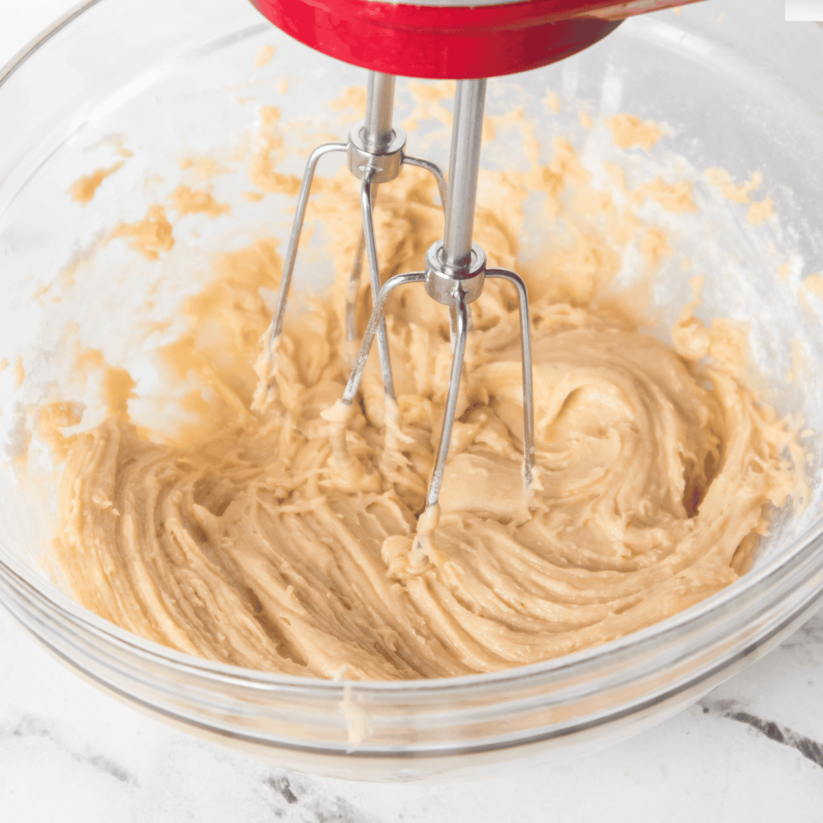 Mixing softened butter and sugar in a large bowl until light and fluffy for soft, tender lemon cookies.