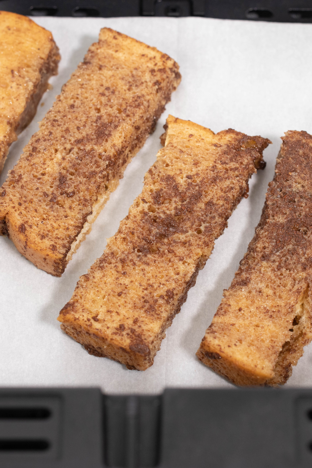 French toast sticks arranged in air fryer basket