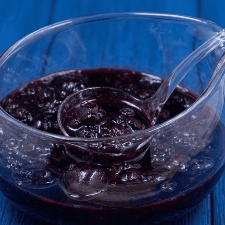 Jar of homemade Instant Pot mixed berry jam with a spoon