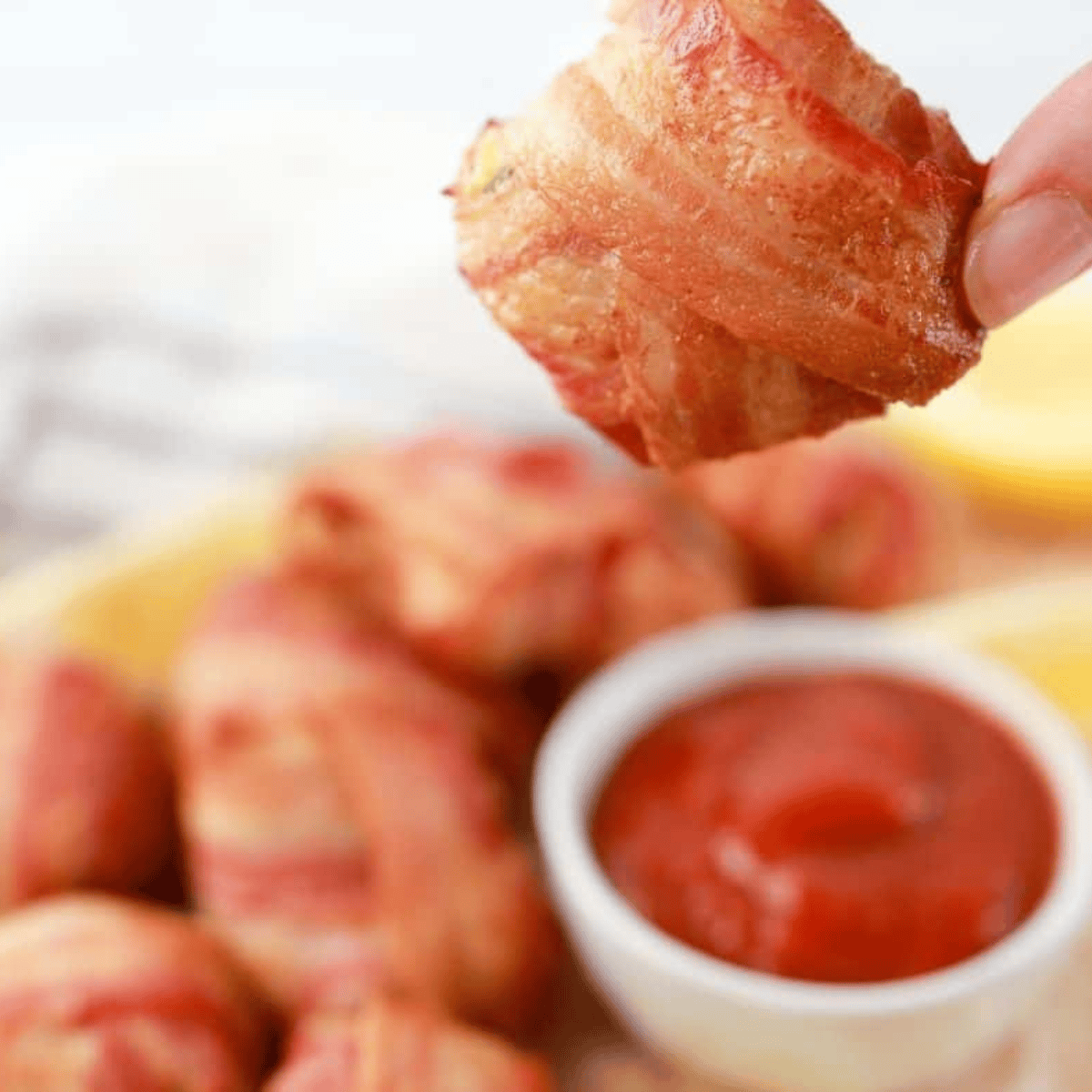 Golden brown bacon-wrapped crab rolls cooked in an air fryer, served on a plate.