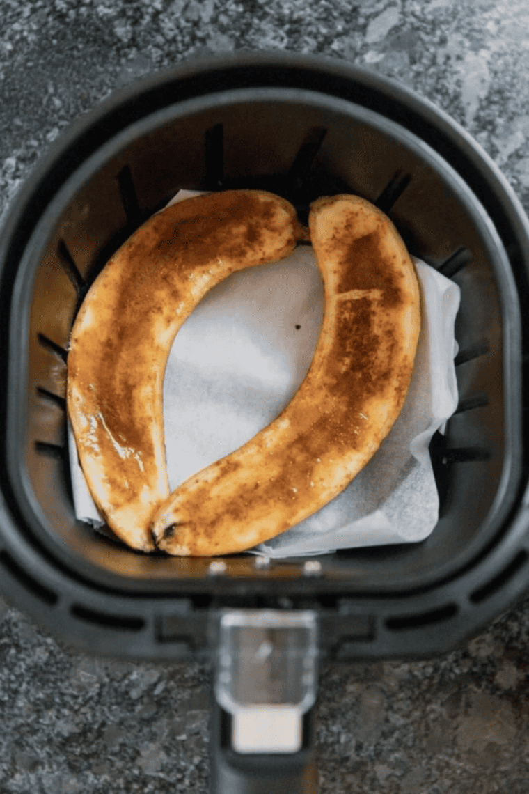 Bananas foster rum sauce simmering in a skillet until glossy and slightly thickened