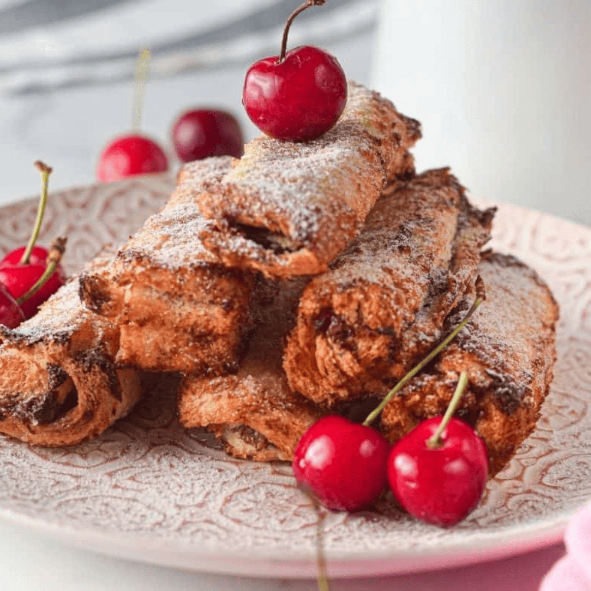 Air fryer French toast stuffed with Nutella and cherries, golden brown and crispy on a plate