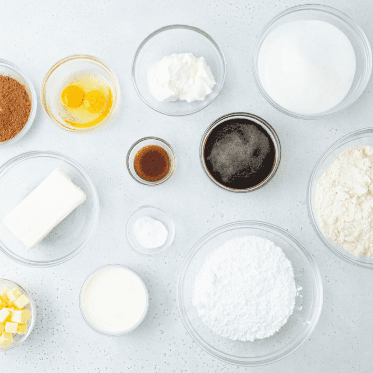 Ingredients for Air Fryer Flourless Chocolate Cake arranged on a table, including dark chocolate, butter, eggs, sugar, cocoa powder, vanilla extract, and salt.