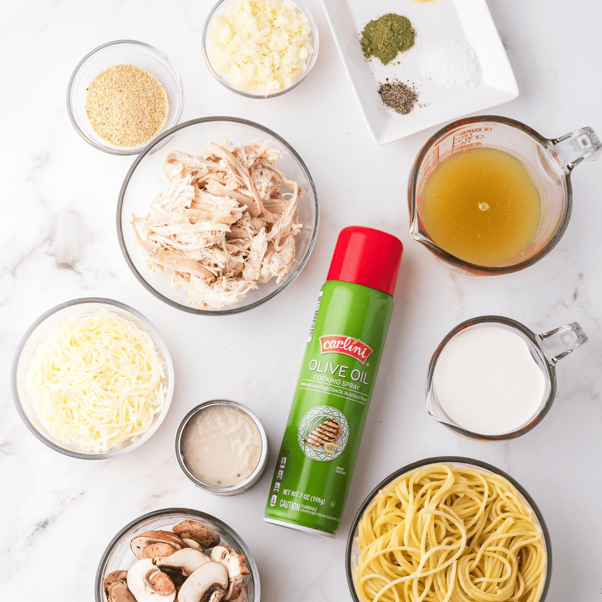 Ingredients for air fryer turkey tetrazzini laid out on a wood cutting board.