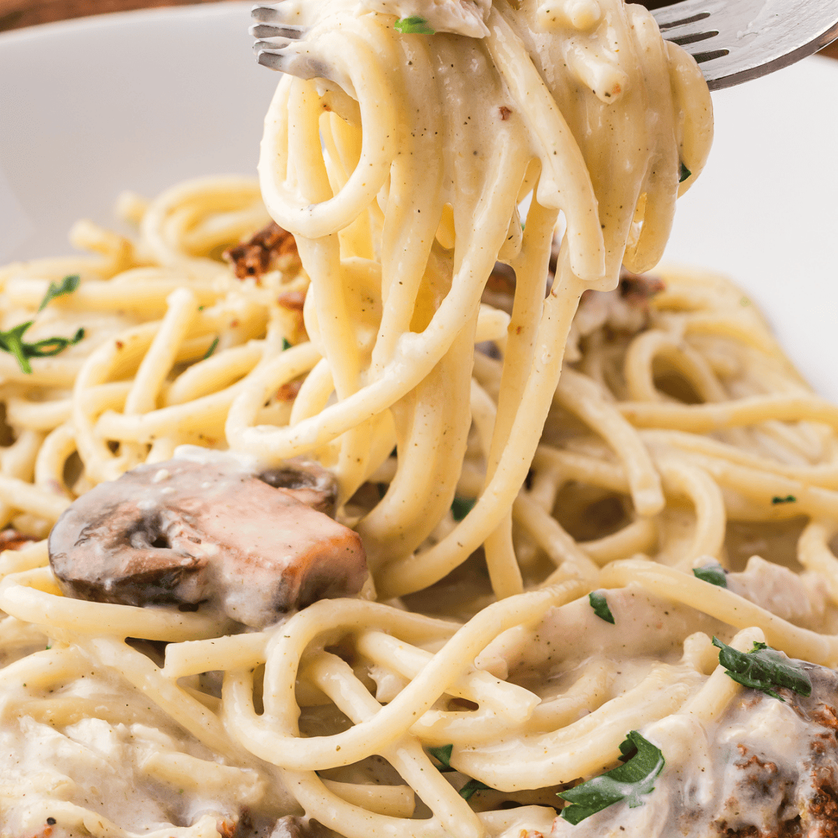 Creamy Air Fryer Turkey Tetrazzini baked until golden brown with turkey, spaghetti, mushrooms, and melted cheese in a casserole dish.