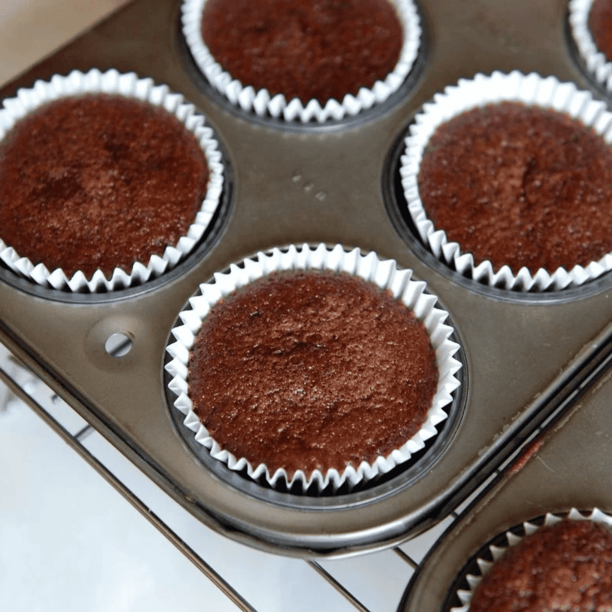 Muffin tin lined with cupcake liners, filled two-thirds full, placed in air fryer to bake until a toothpick comes out clean.