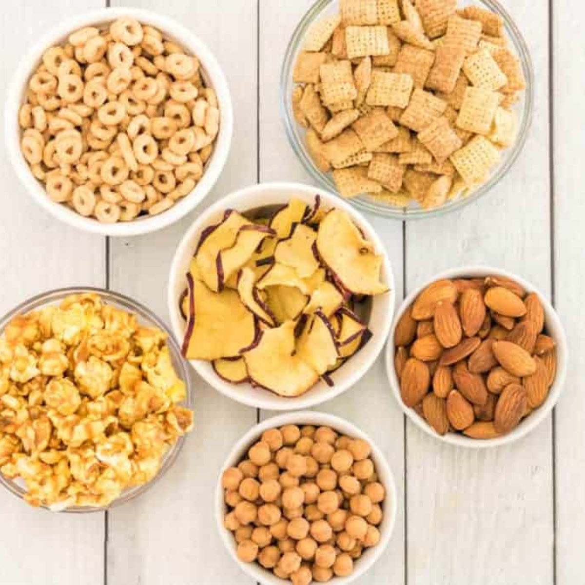 Cinnamon Chex, apple cinnamon Cheerios, caramel corn, dried apple chips, almonds, and caramel bits in prep bowls