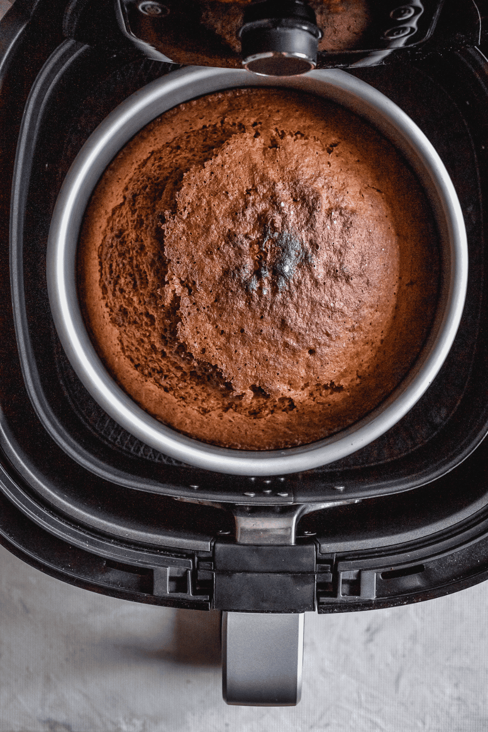 Air Fryer Walnut Cake with golden brown top, garnished with chopped walnuts, ready to serve.