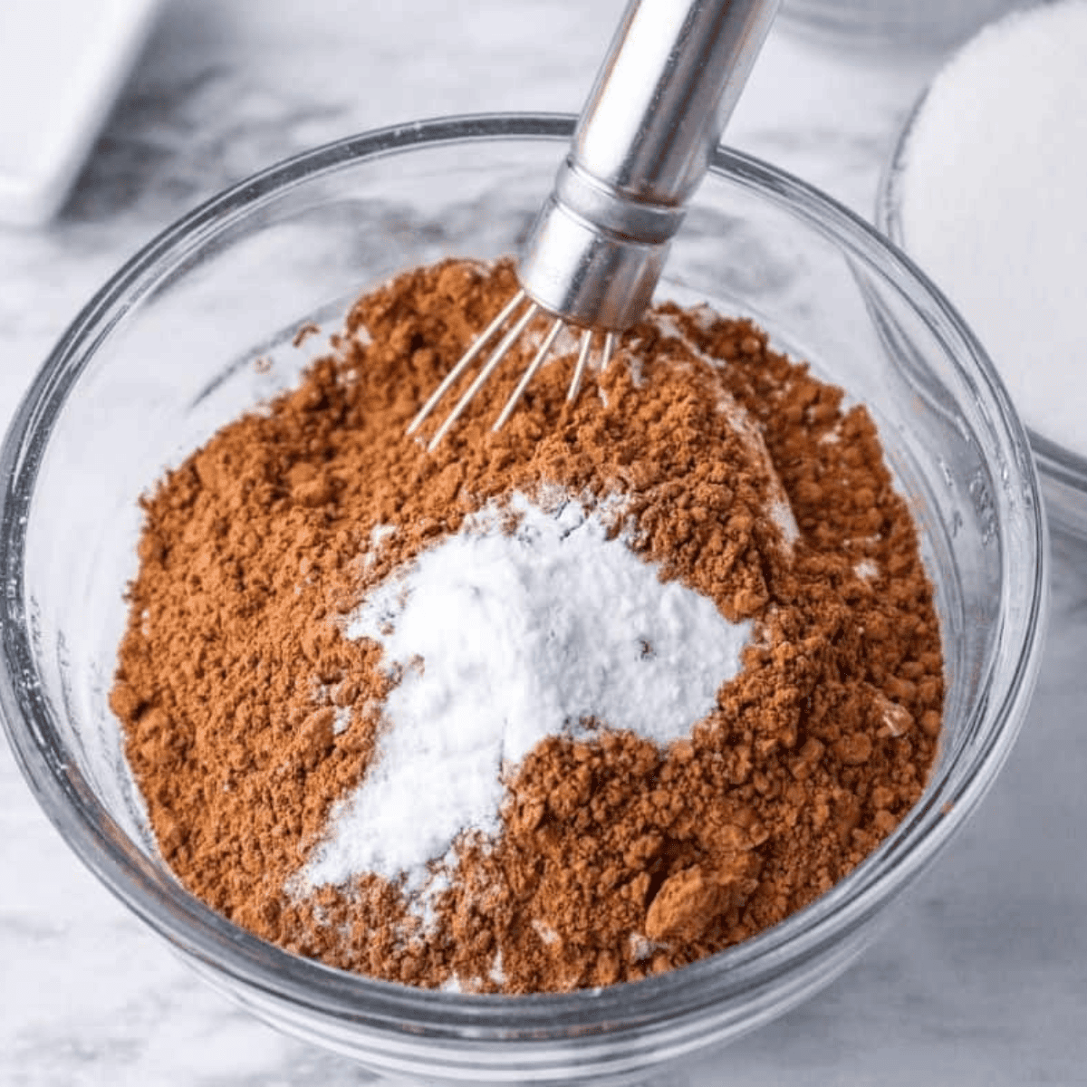 Whisking flour baking soda salt and cocoa powder in a bowl.