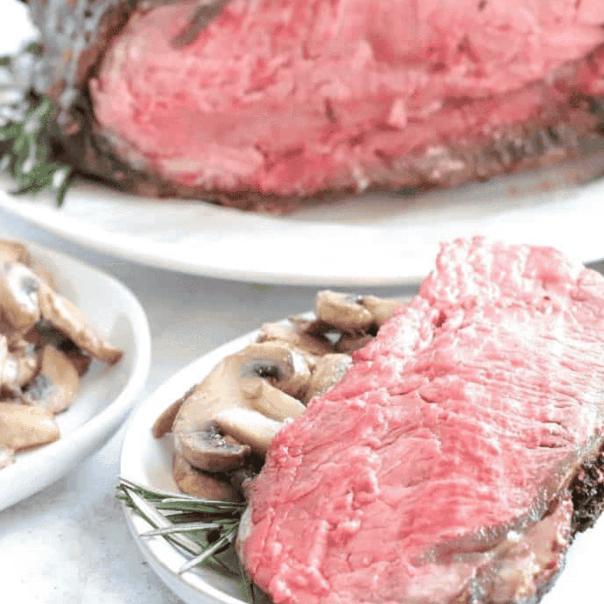 Slice of medium rare prime rib cooked in the air fryer, served on a white plate