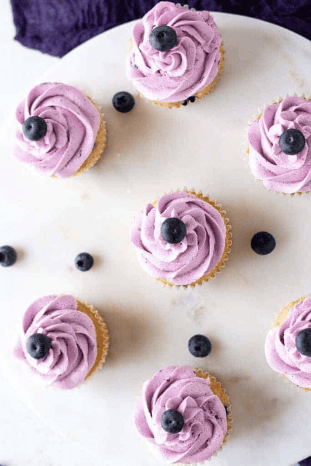 Air fryer blueberry cupcakes in paper liners, golden and fluffy, filled with fresh blueberries.