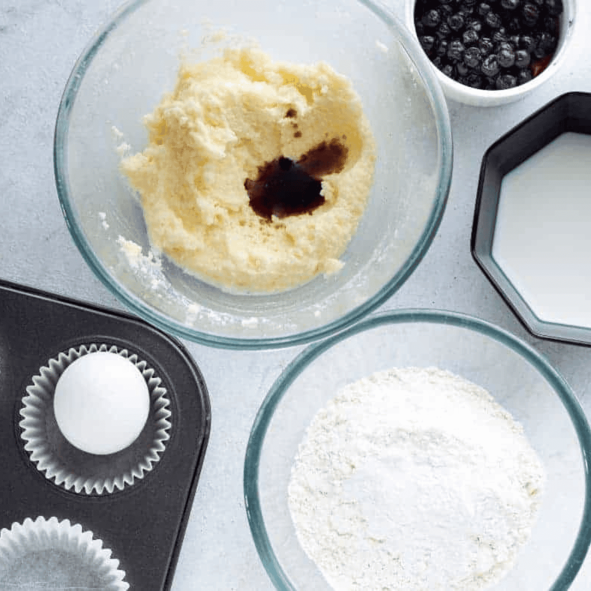 Lining a muffin pan with cupcake liners or spraying with cooking spray for baking.