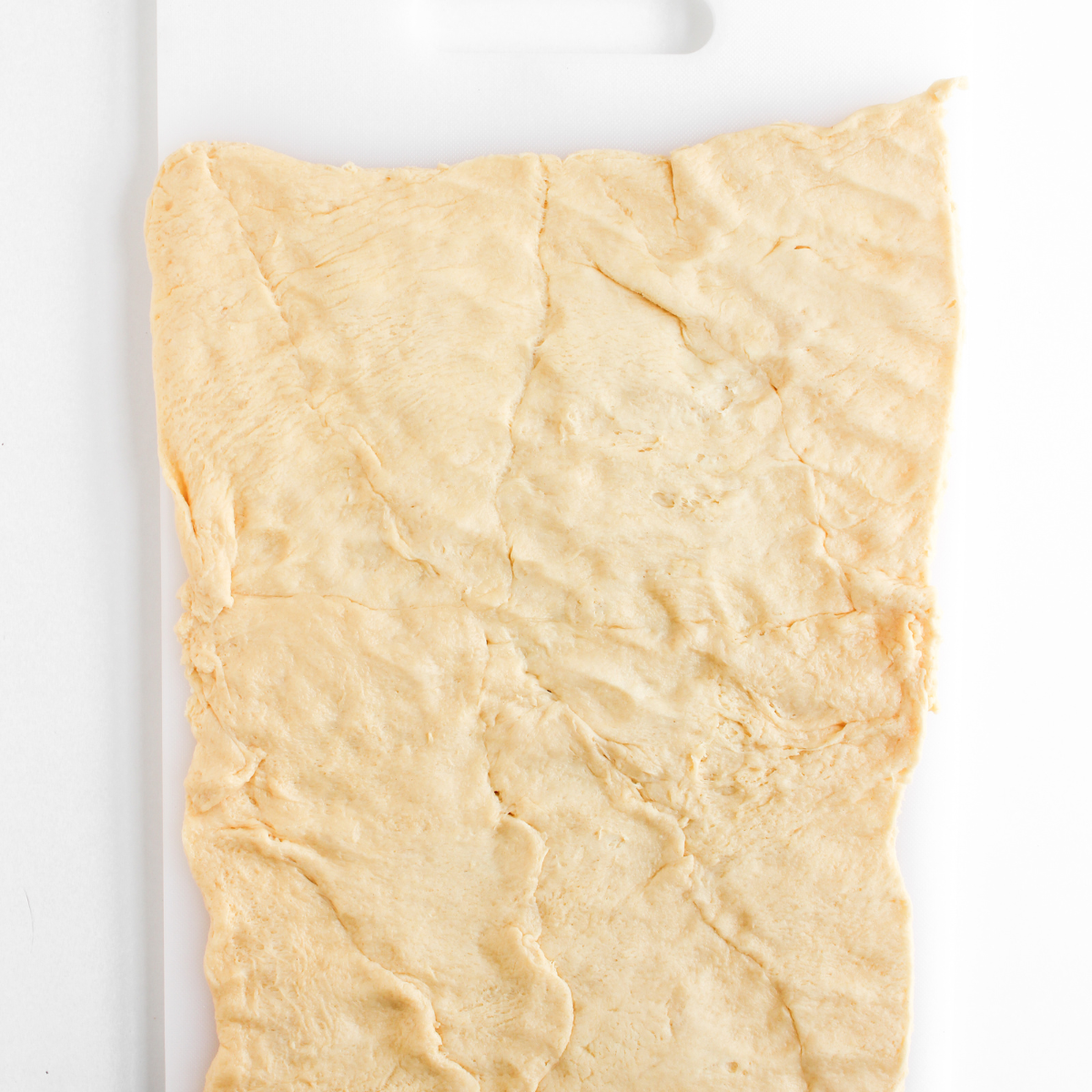 Flattening the dough on a cutting board.