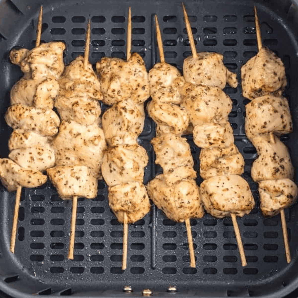 Air Fryer Greek Chicken Kebabs cooking in a single layer in the air fryer basket