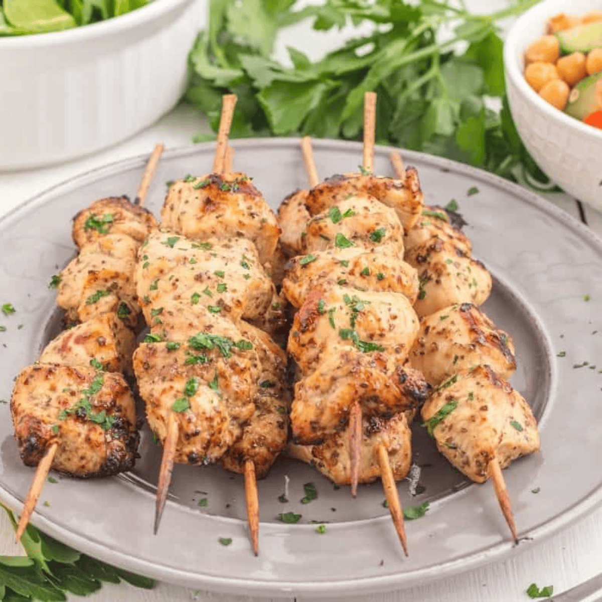 Finished Air Fryer Greek Chicken Kebabs garnished with fresh parsley and served with tzatziki