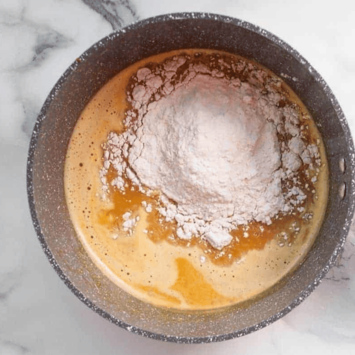 Mixing butter, water, and pumpkin in a saucepan for churro dough.